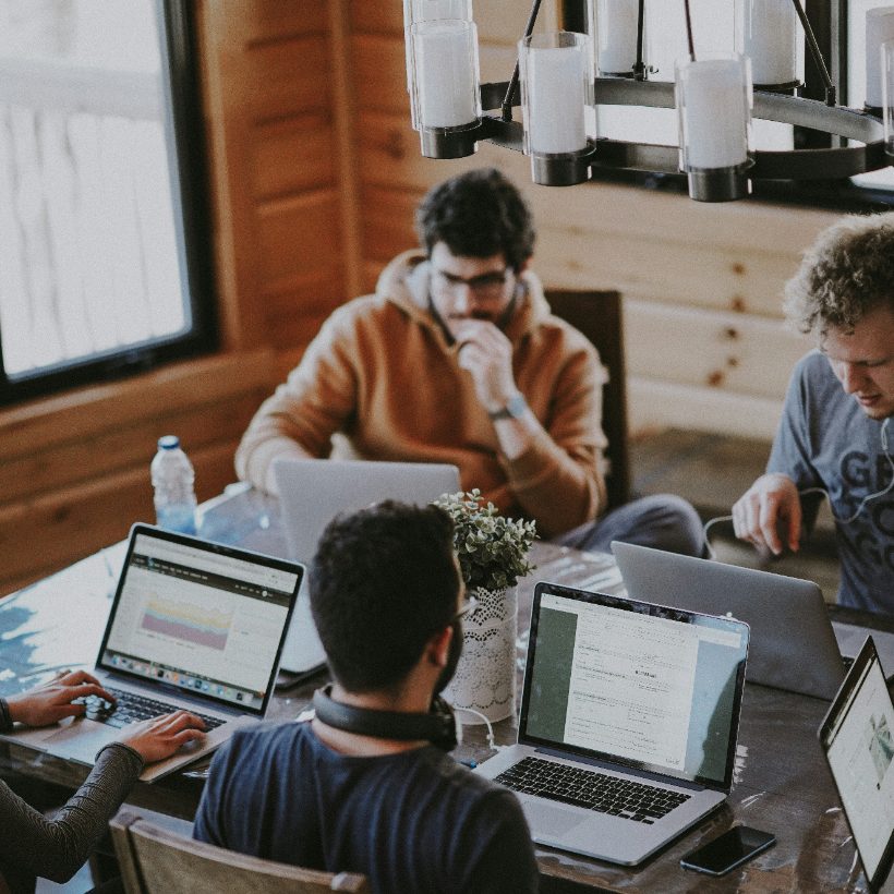 A team working together around a table, heads down on the problem